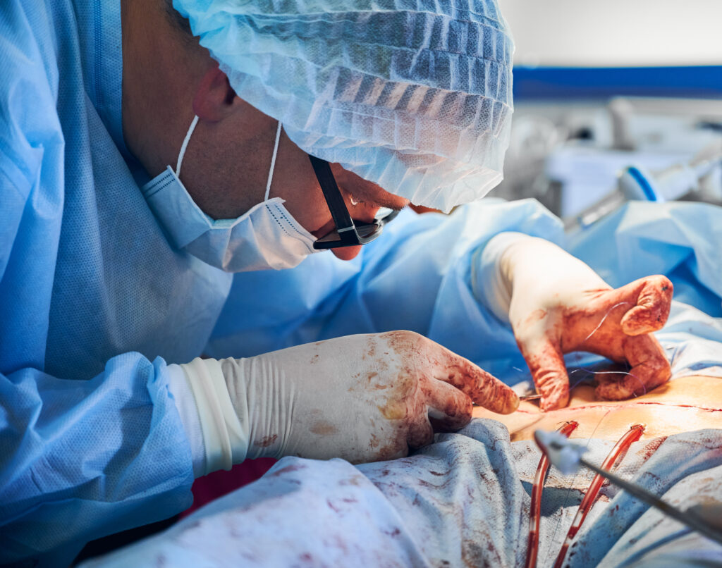 Male doctor stitching